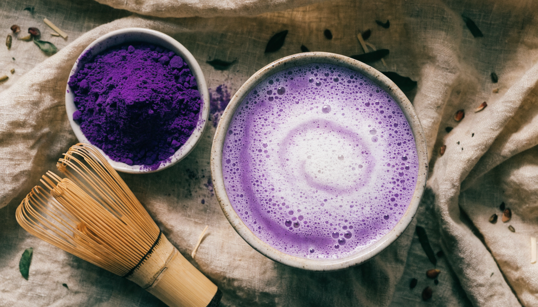 Ube latte violet en flat lay avec un bol de poudre d'ube et un fouet en bambou – Pure Tea